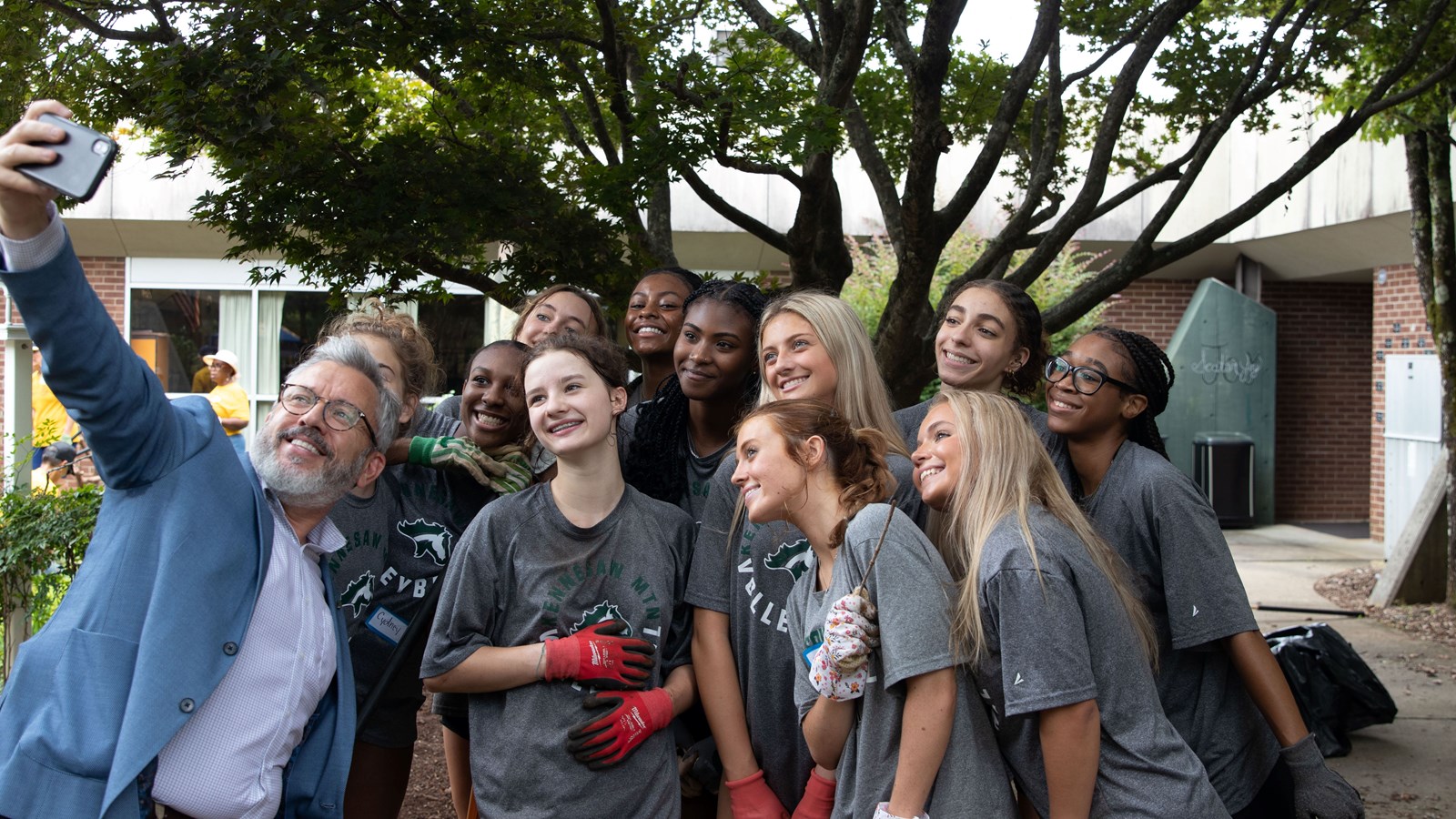 Principal David poses with members of the Kennesaw Mountain High School Volleyball team while they are volunteering at Pine Mountain Middle School to refresh the school's garden space.